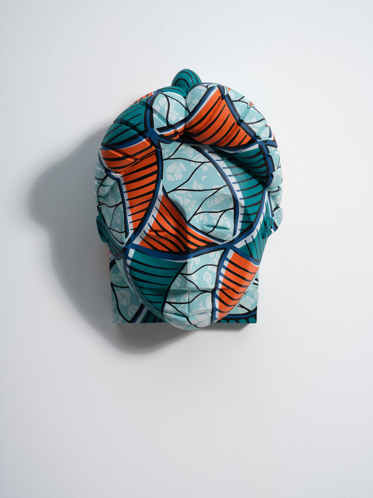 A blue and orange sculpture on a white wall.
