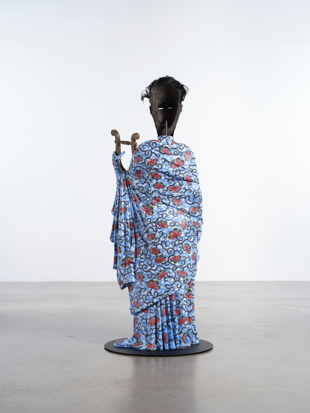 Artwork by Yinka Shonibare, Hybrid Sculpture (Terpsichore / Bété-Guro Mask), Made of Fibreglass sculpture, hand-painted with Dutch wax pattern, hand-carved wooden mask and steel baseplate or plinth 