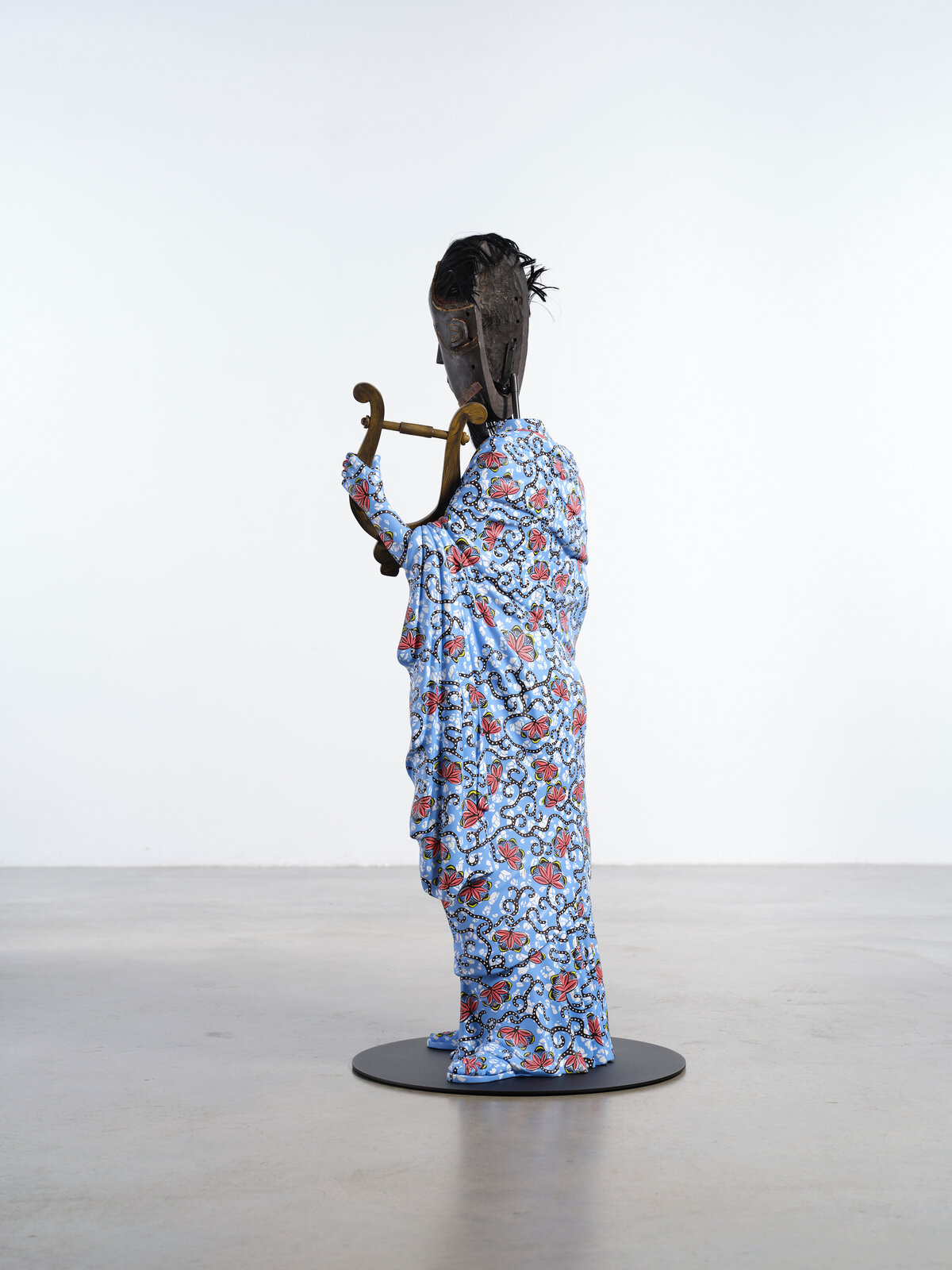 Artwork by Yinka Shonibare, Hybrid Sculpture (Terpsichore / Bété-Guro Mask), Made of Fibreglass sculpture, hand-painted with Dutch wax pattern, hand-carved wooden mask and steel baseplate or plinth 