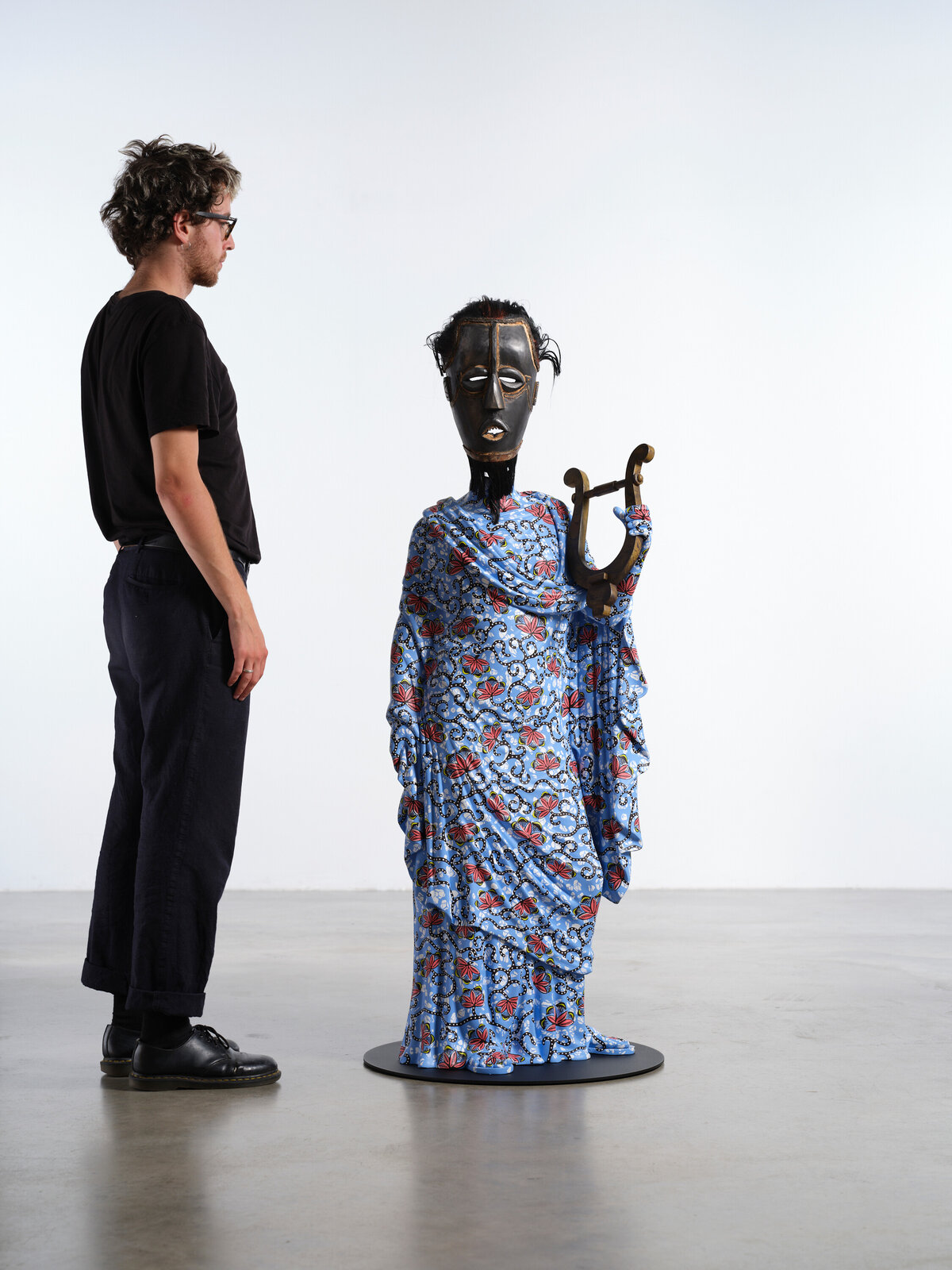 Artwork by Yinka Shonibare, Hybrid Sculpture (Terpsichore / Bété-Guro Mask), Made of Fibreglass sculpture, hand-painted with Dutch wax pattern, hand-carved wooden mask and steel baseplate or plinth 