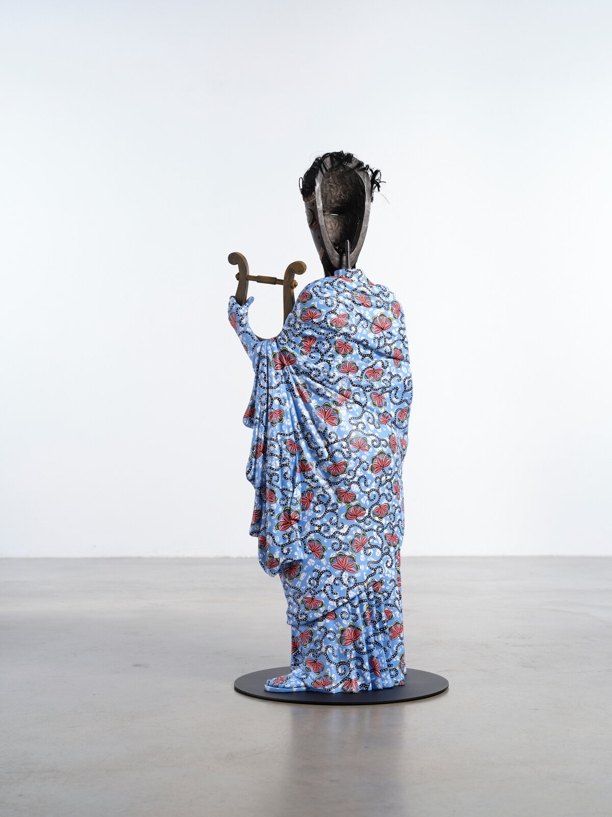 Artwork by Yinka Shonibare, Hybrid Sculpture (Terpsichore / Bété-Guro Mask), Made of Fibreglass sculpture, hand-painted with Dutch wax pattern, hand-carved wooden mask and steel baseplate or plinth 