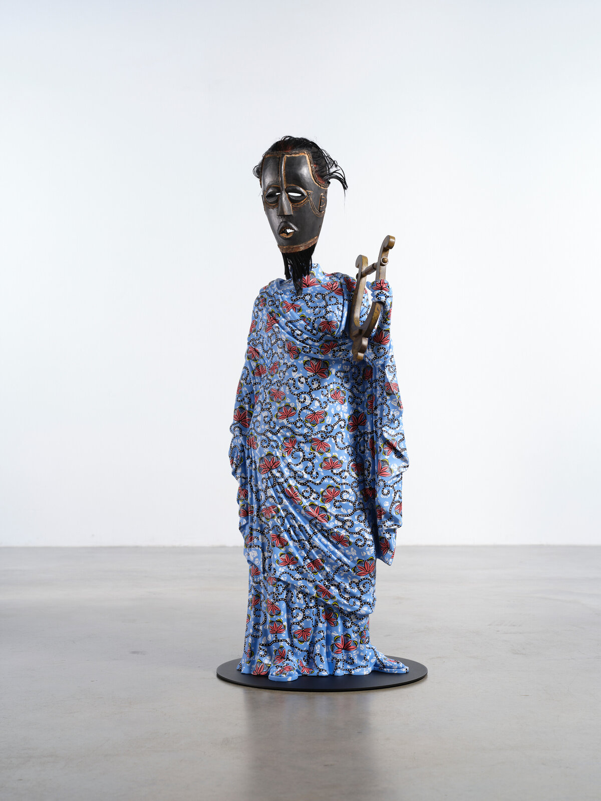 Artwork by Yinka Shonibare, Hybrid Sculpture (Terpsichore / Bété-Guro Mask), Made of Fibreglass sculpture, hand-painted with Dutch wax pattern, hand-carved wooden mask and steel baseplate or plinth 