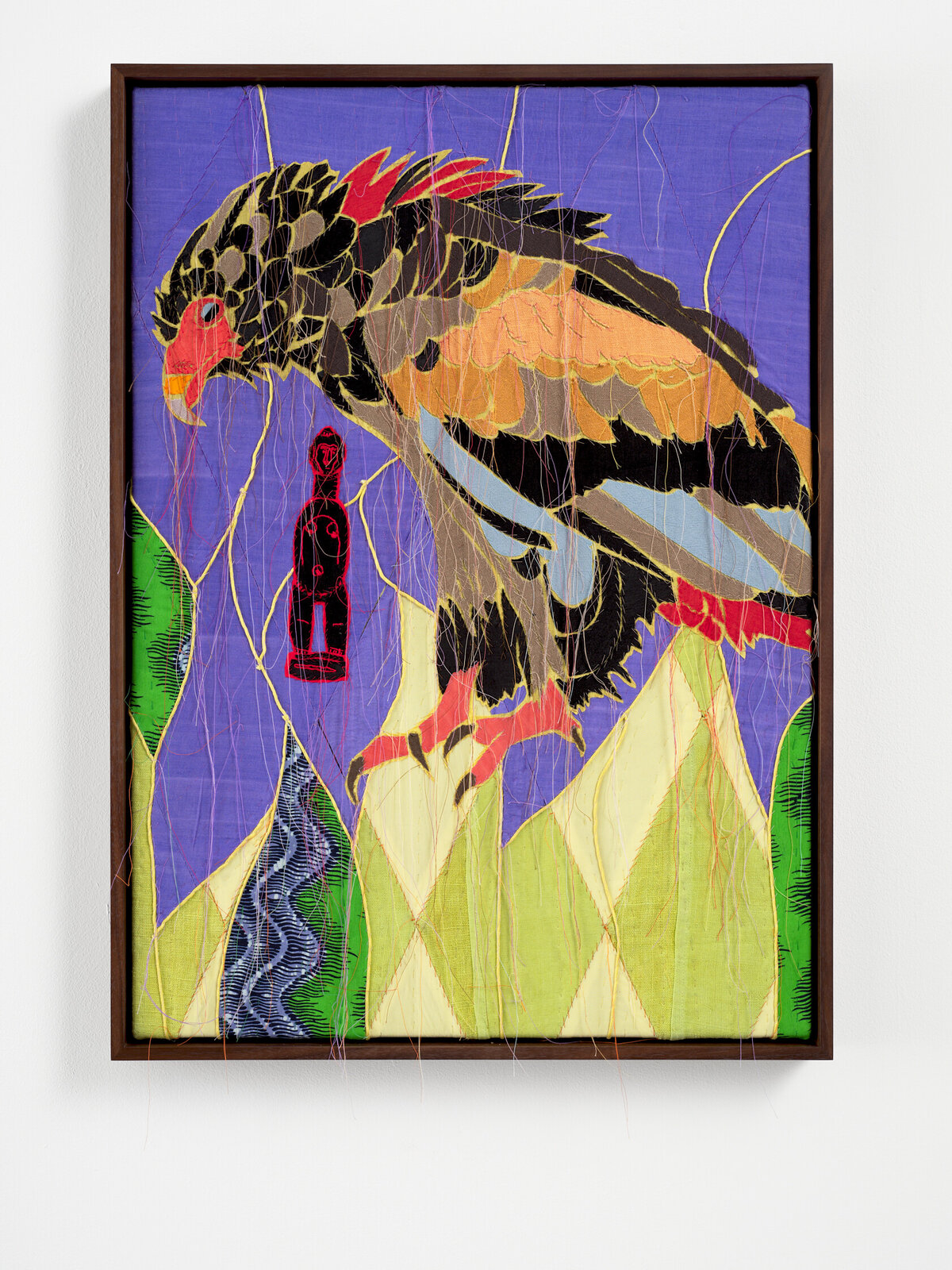 A colorful textile artwork featuring a large bird perched over stylized mountains with a small red figure in the background.
