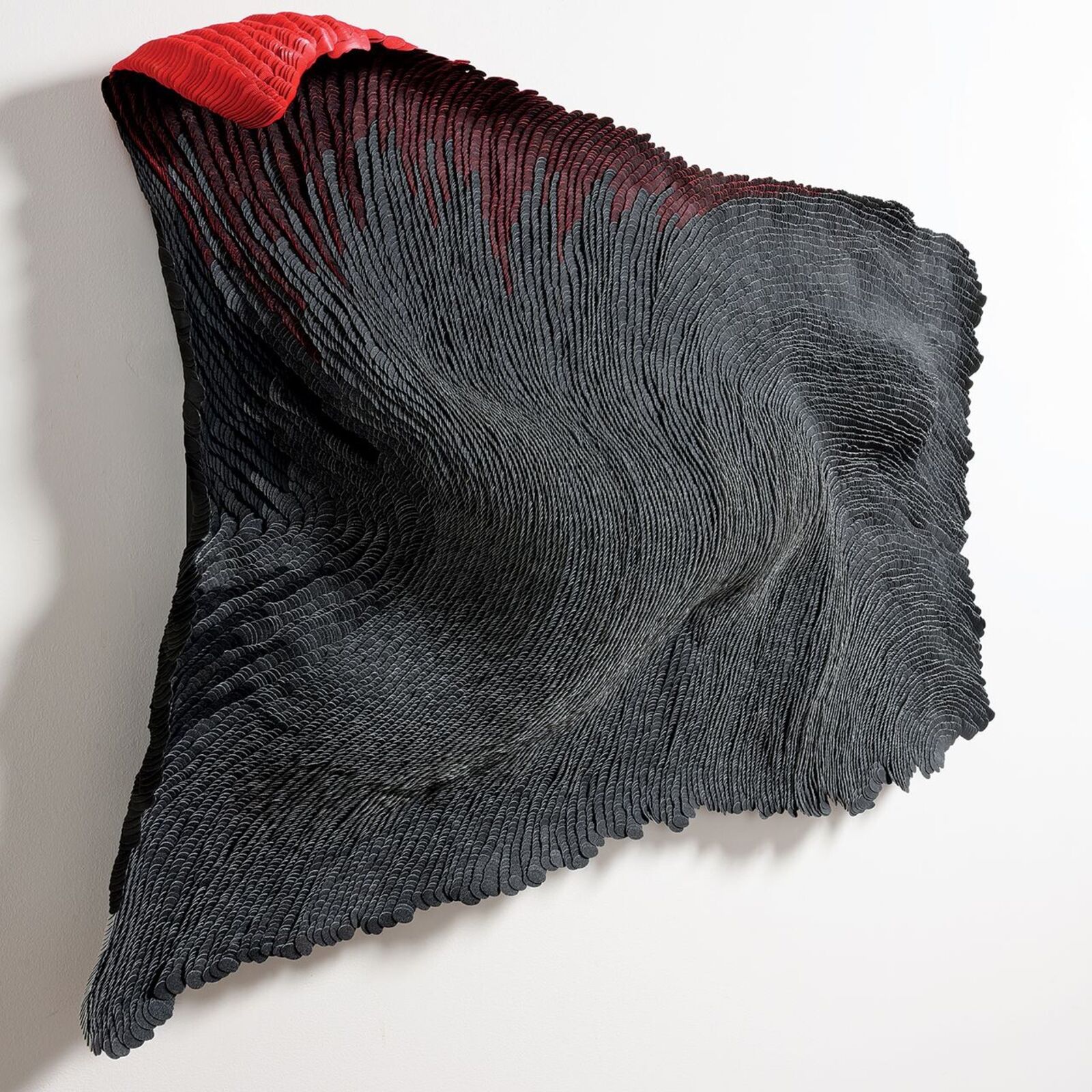 A black and red piece of art hanging on a wall.