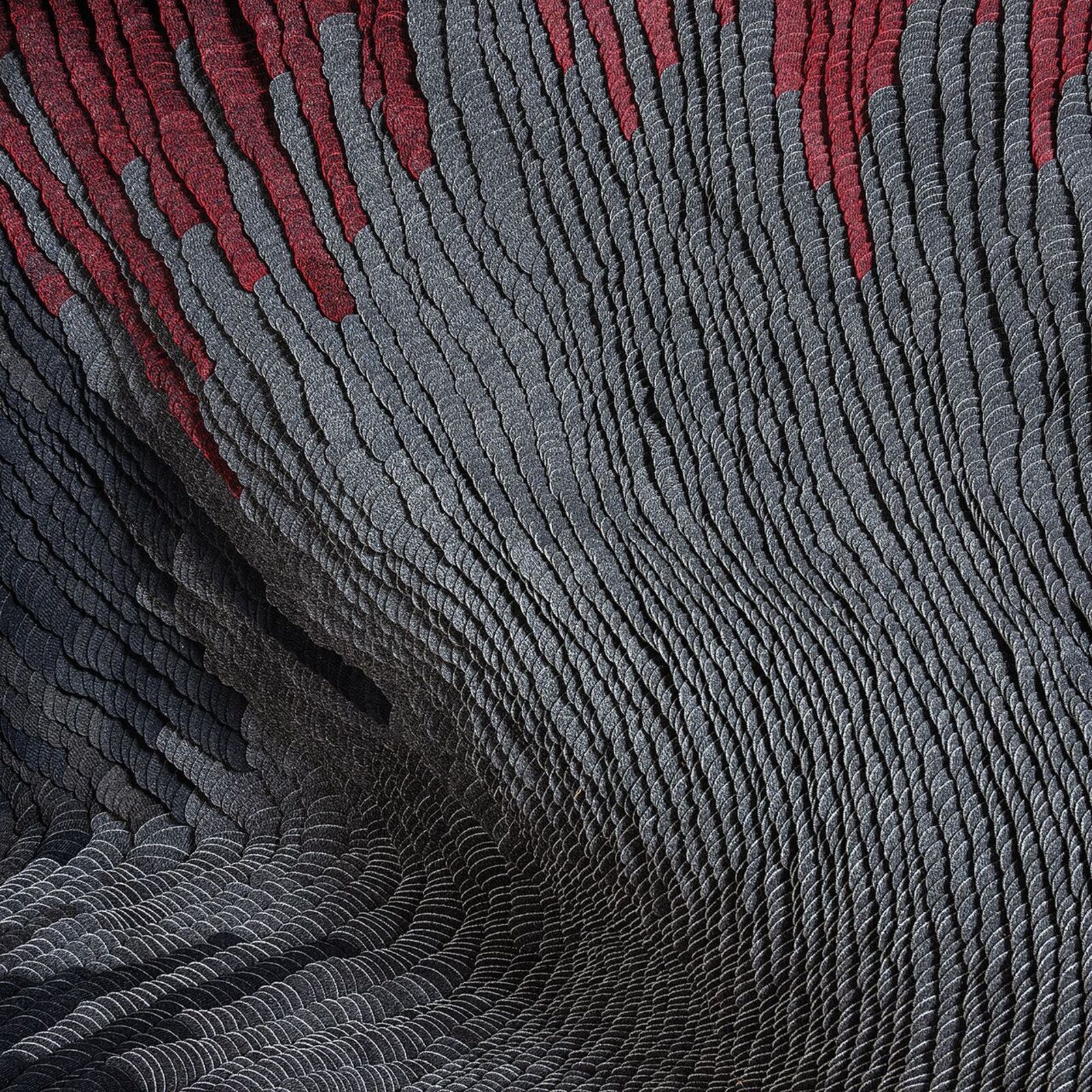 A black and red piece of art hanging on a wall.