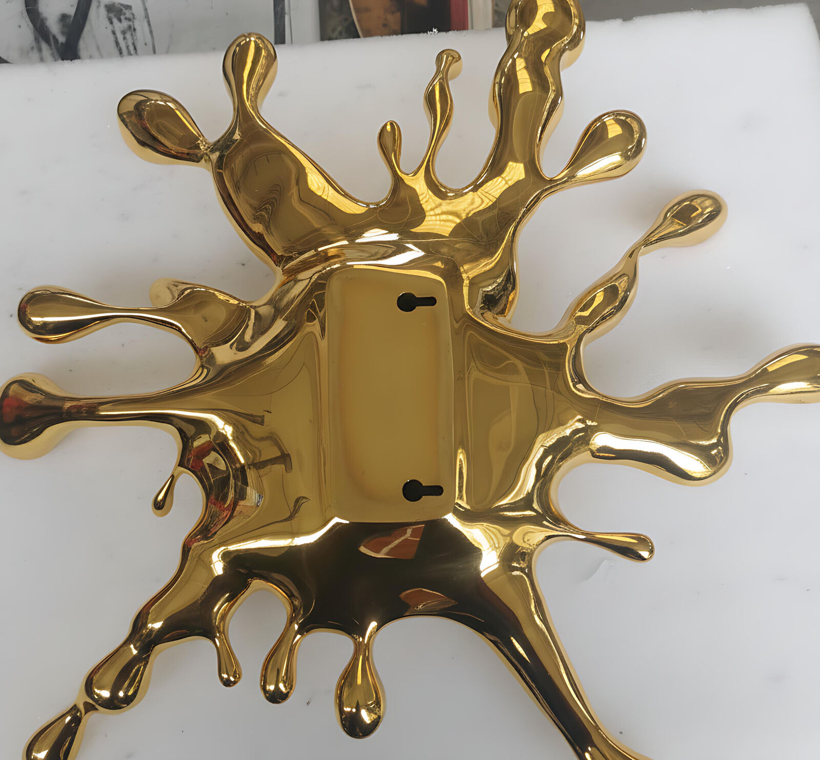 A gold splatter on a white wall. 