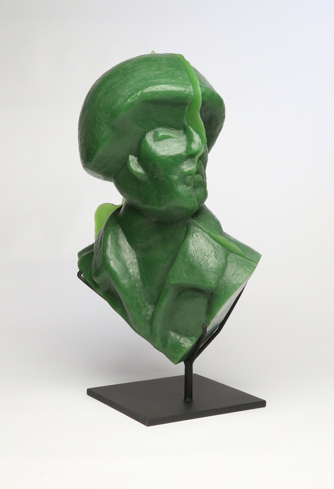 A glossy green bust sculpture displayed on a black metal stand.