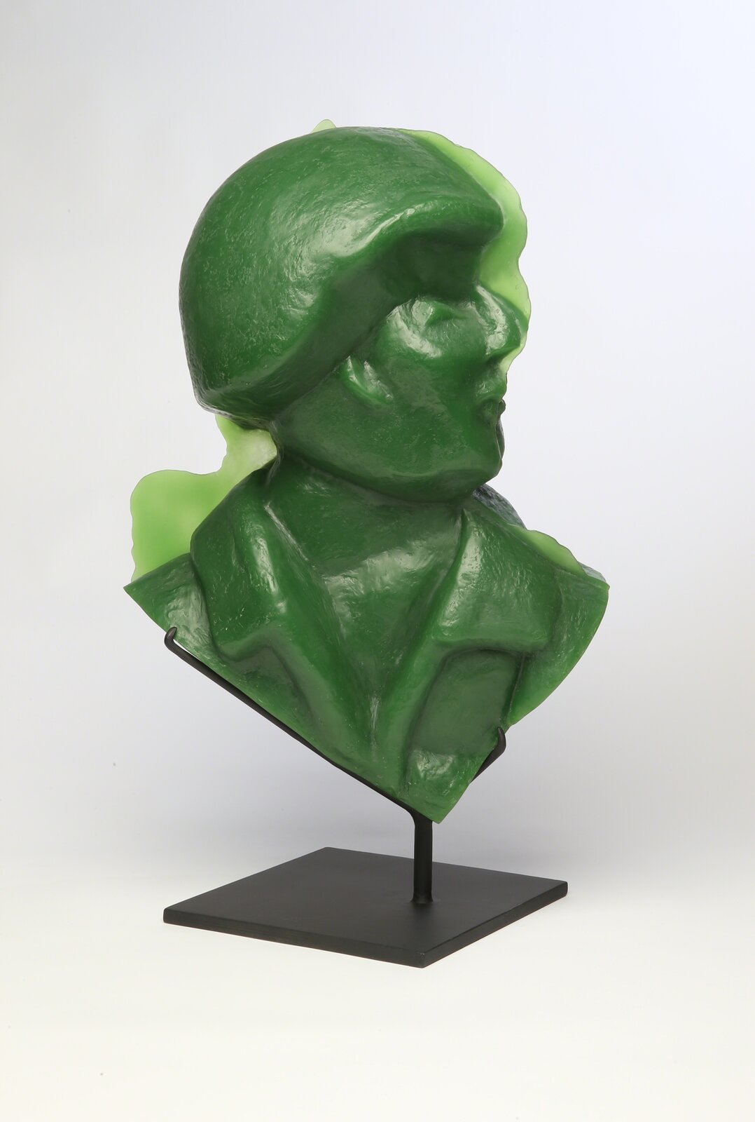 A glossy green bust sculpture displayed on a black metal stand.