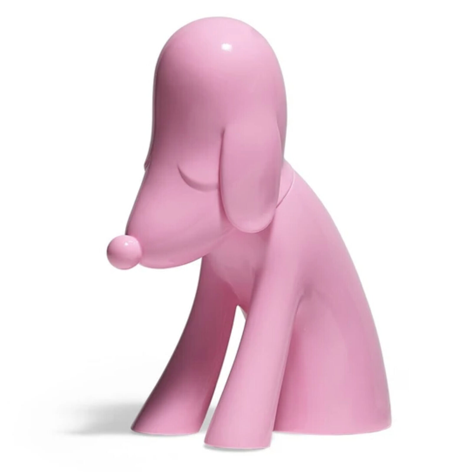 A pink dog figurine sitting on a white surface.