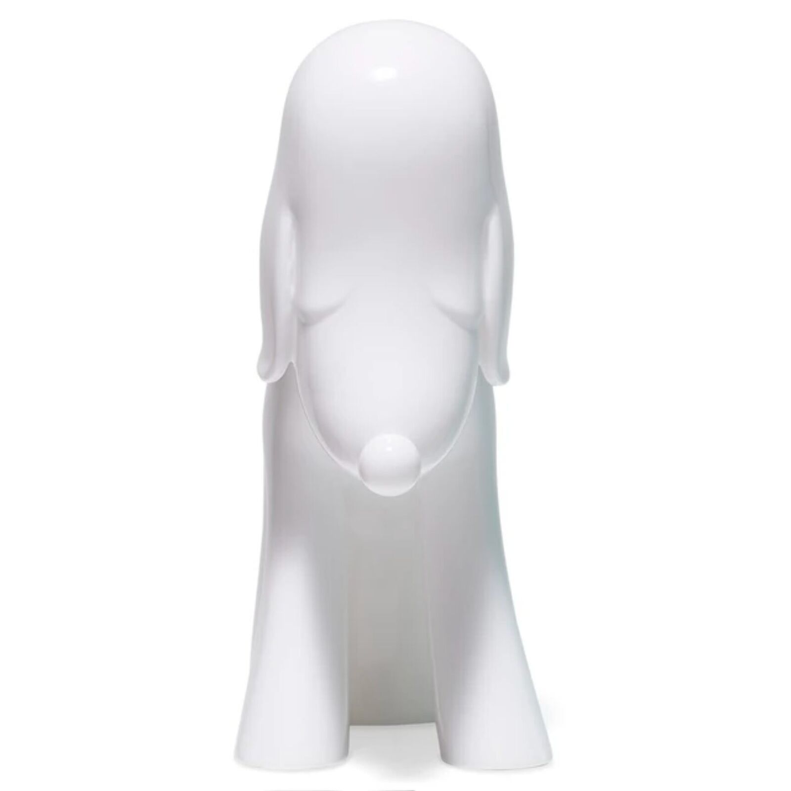 A white dog figurine sitting on a white surface.