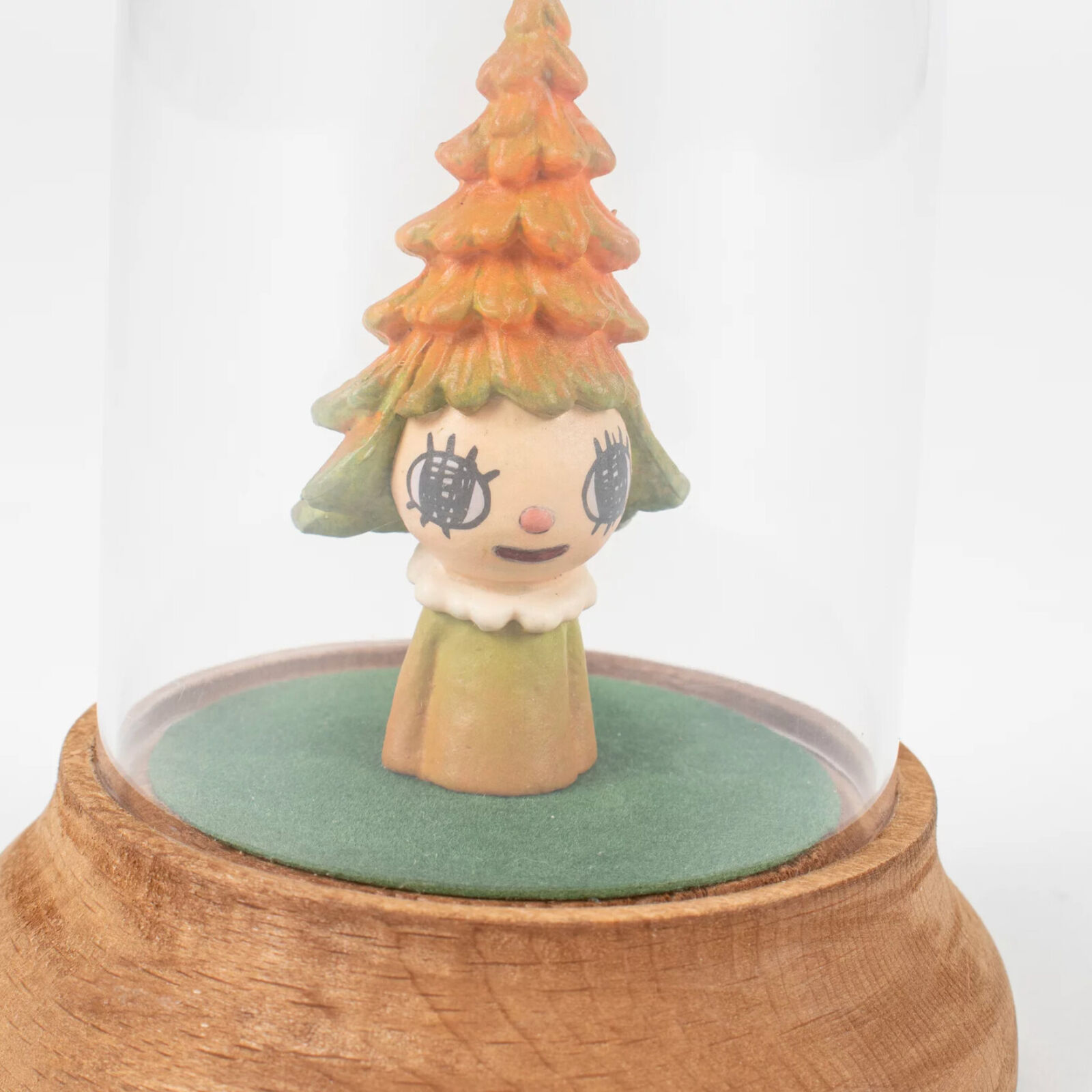 A small figurine of a little girl under a glass dome.