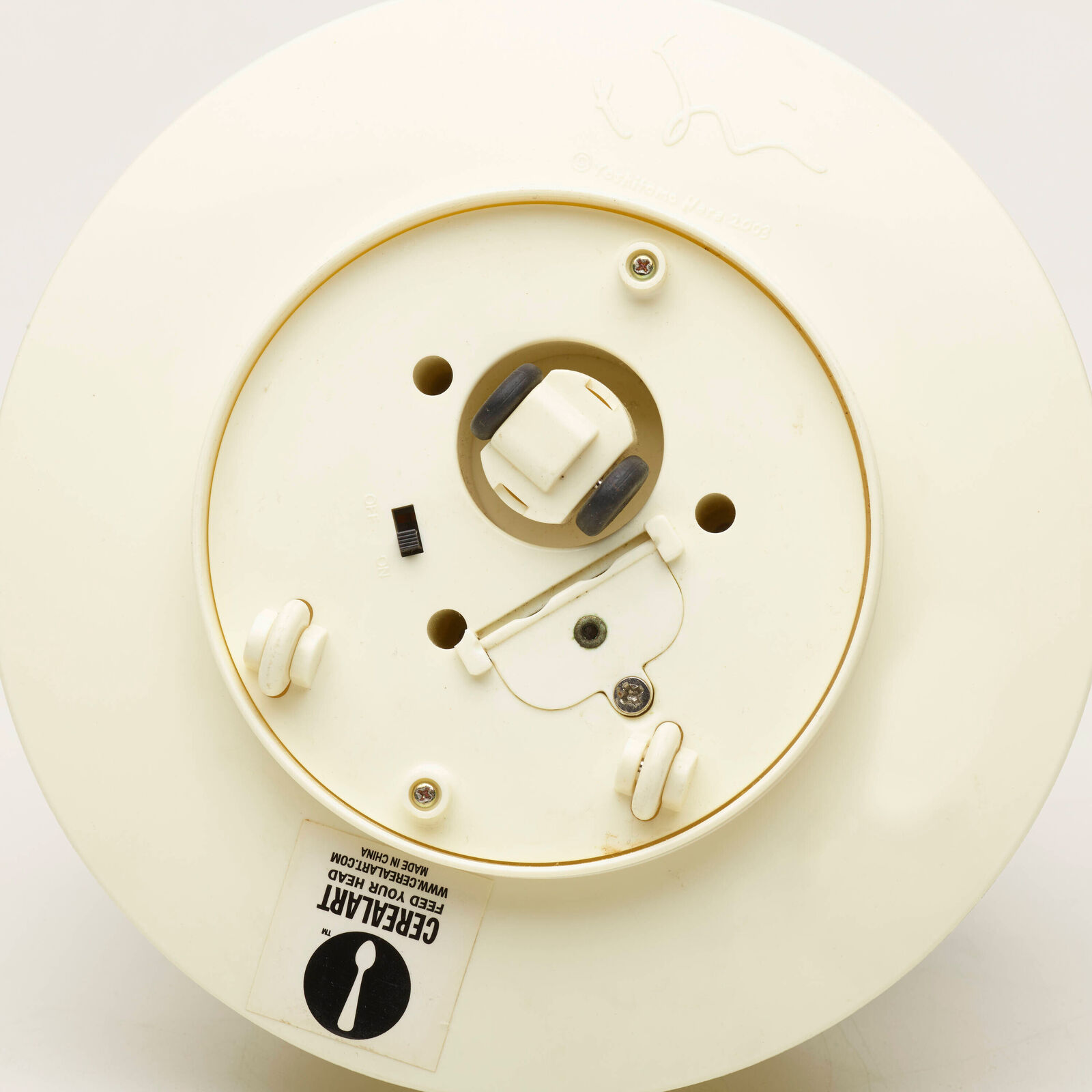 A small figurine of a dog sitting in a bowl of water.