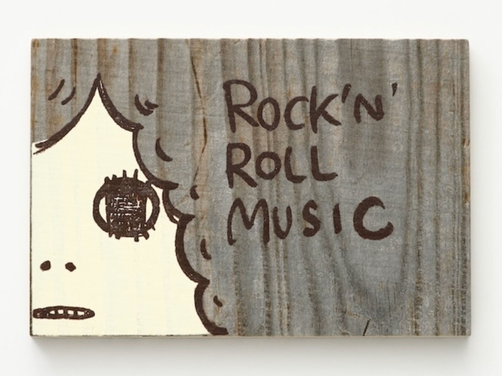 A wooden sign with a drawing of a man's face on it.