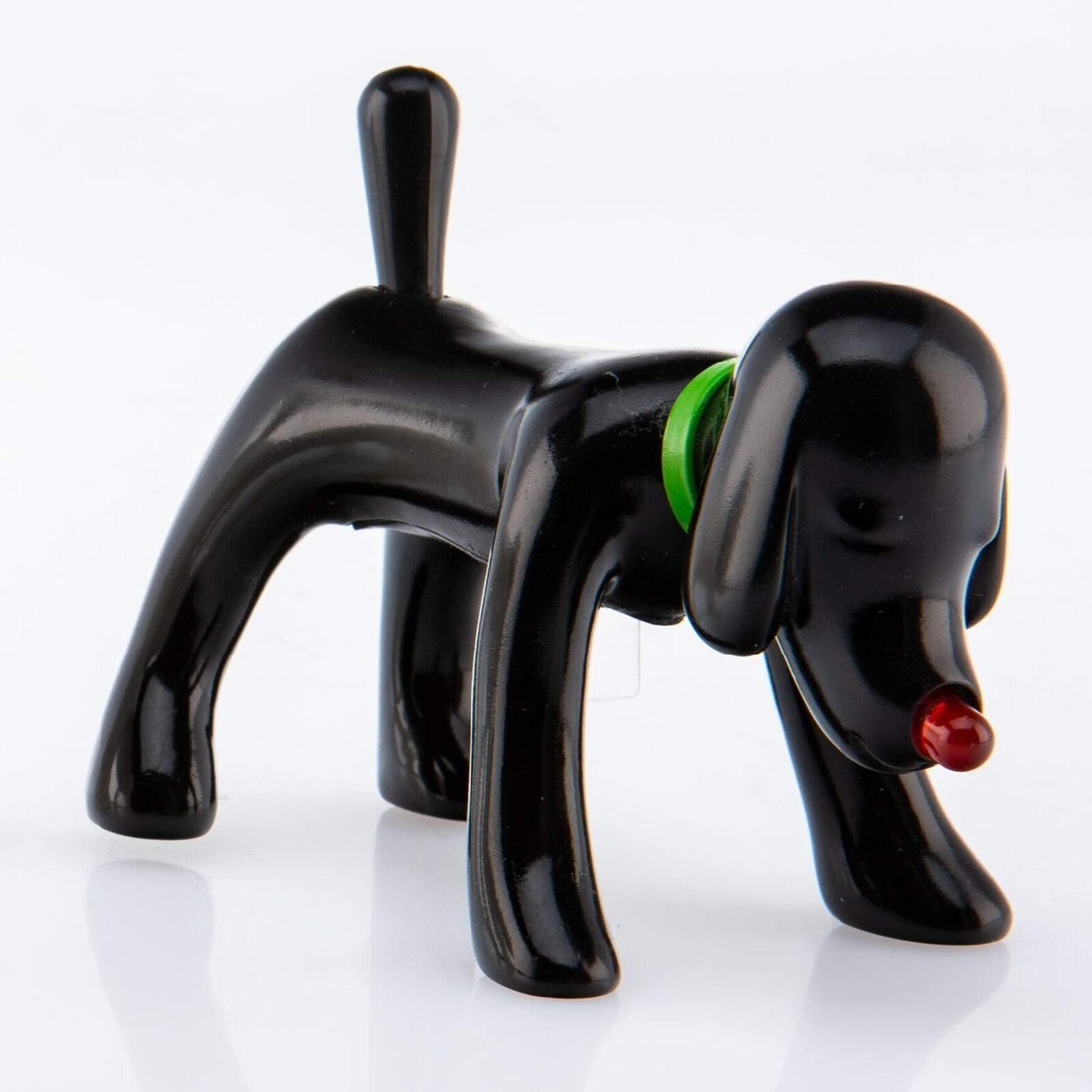 A black dog figurine with a green collar and red nose.