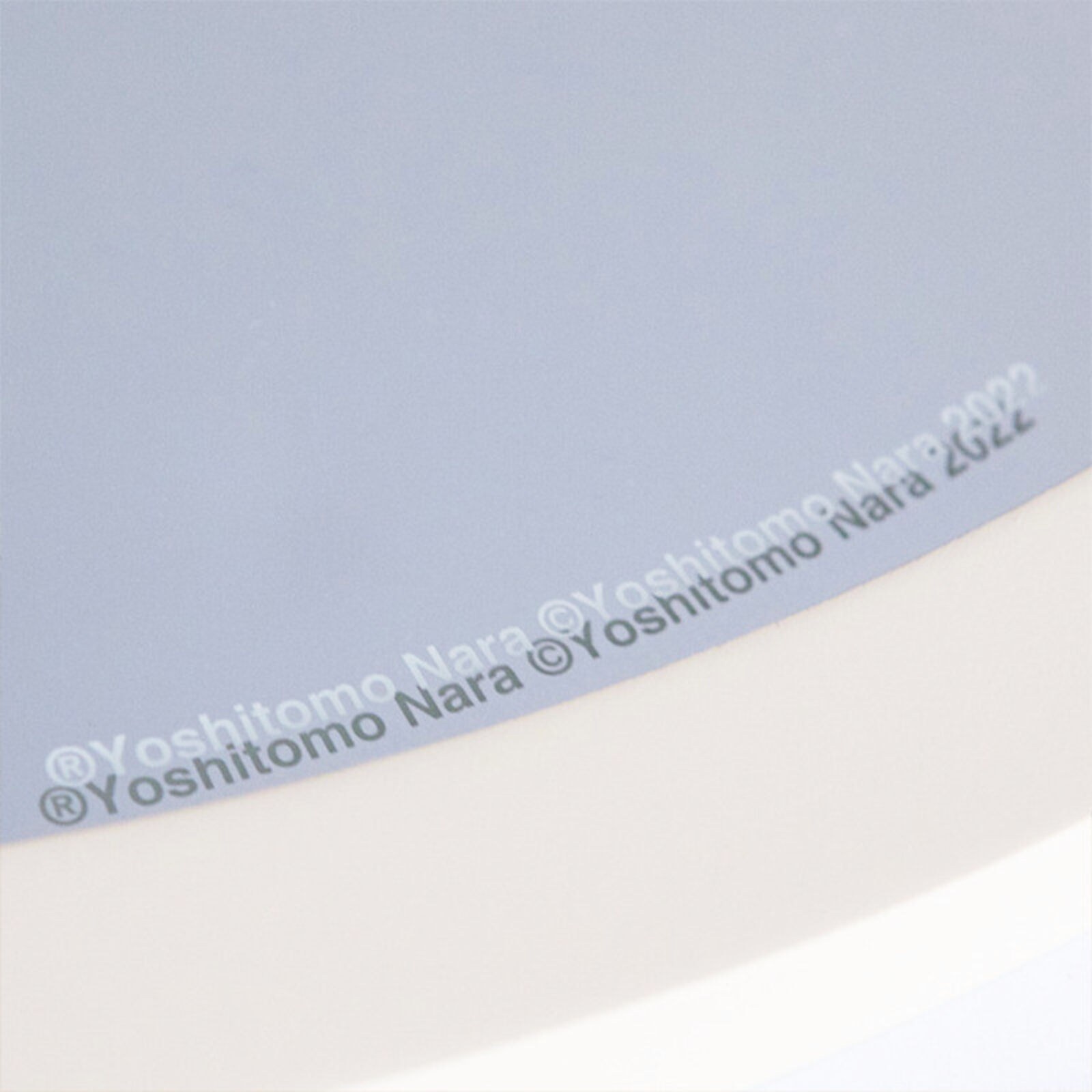 A round mirror with a drawing of a girl holding a flower.