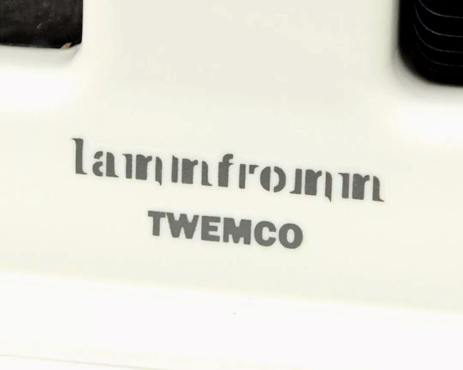 A white alarm clock with a picture of a man and a woman on it.