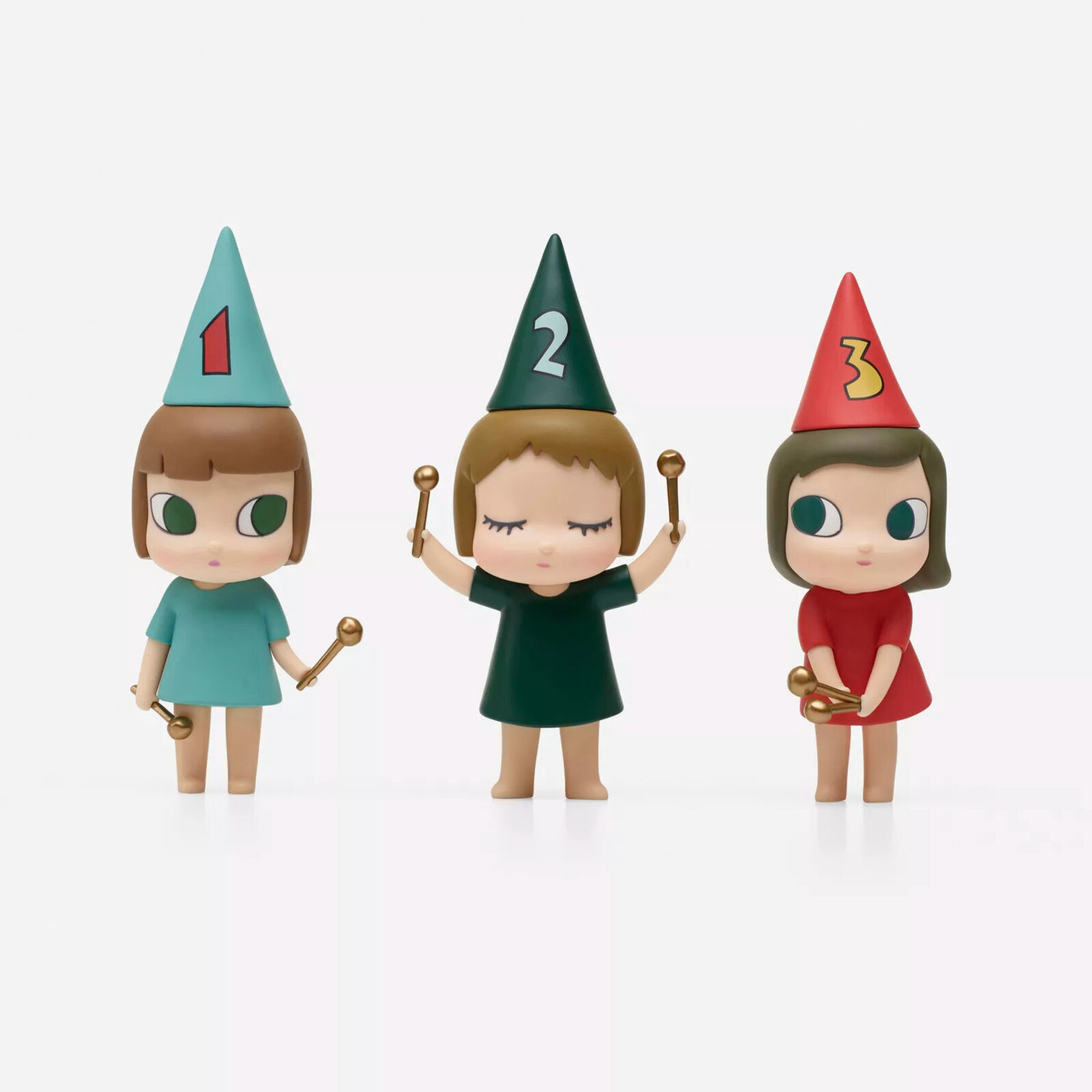 A group of three figurines of a girl in a party hat holding a wand.
