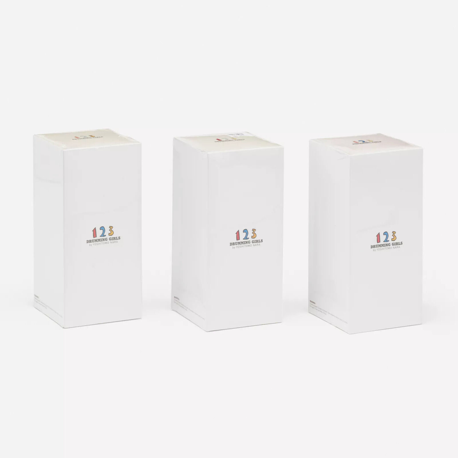 A group of three figurines of a girl in a party hat holding a wand.