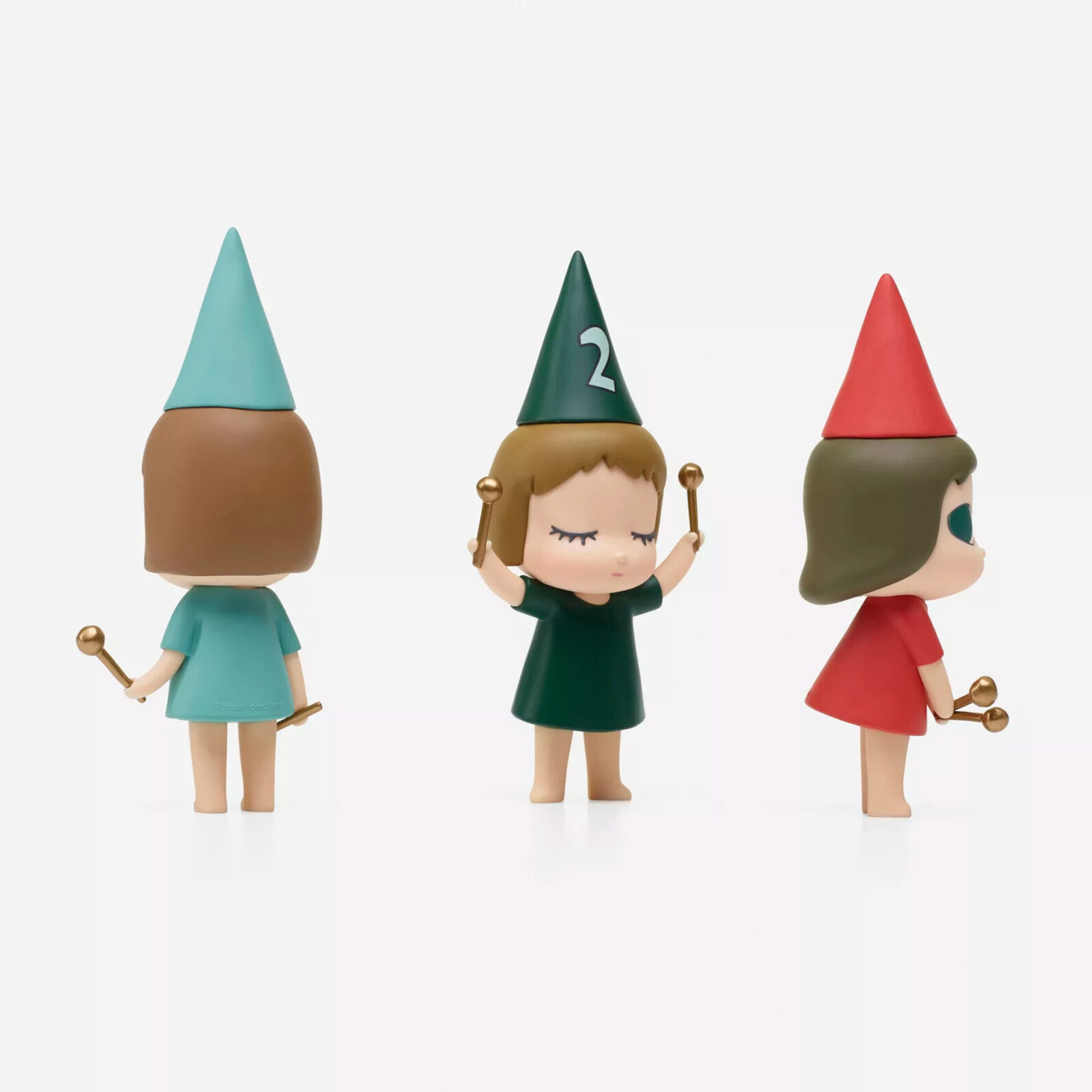 A group of three figurines of a girl in a party hat holding a wand.