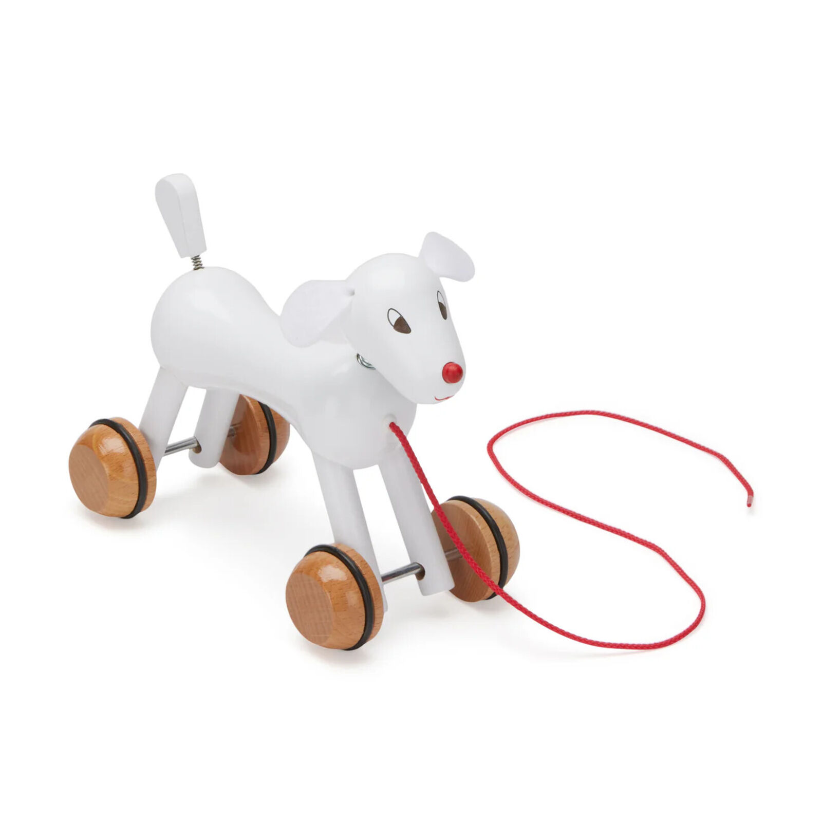A wooden toy dog pulling a red leash.
