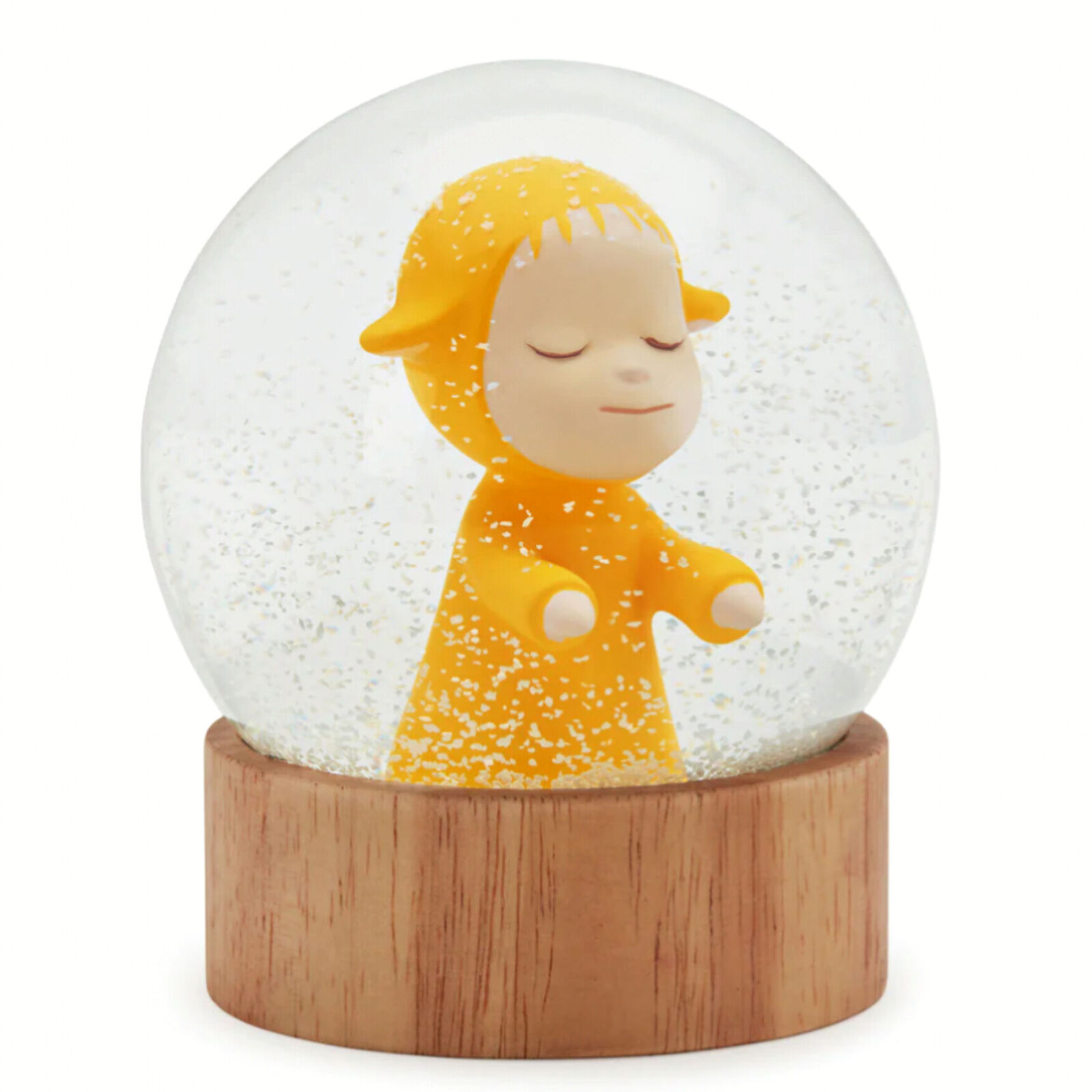 A snow globe with a little girl in a yellow dress.
