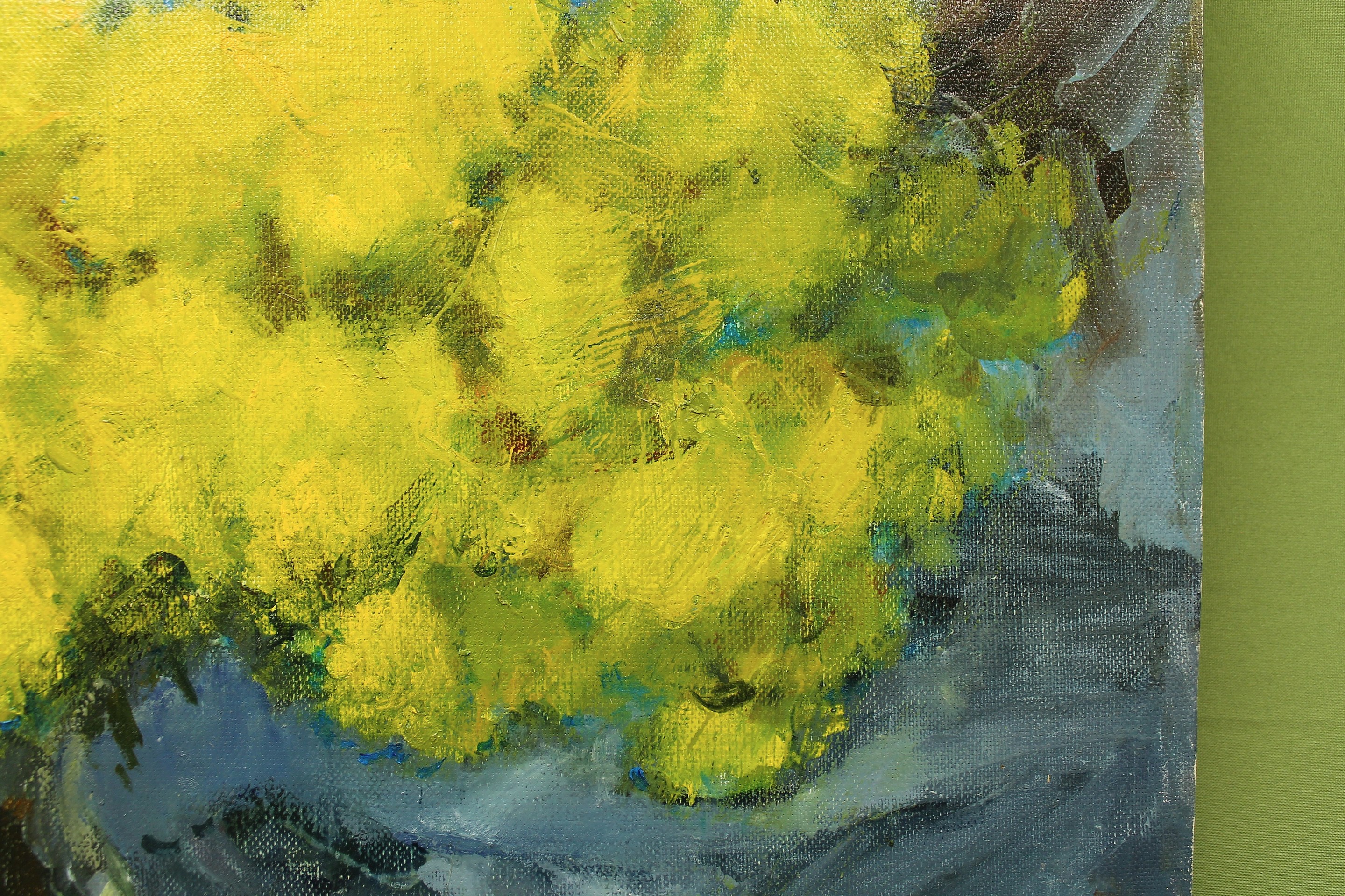 A vibrant still life featuring a vase of bright yellow flowers against a cool blue background.