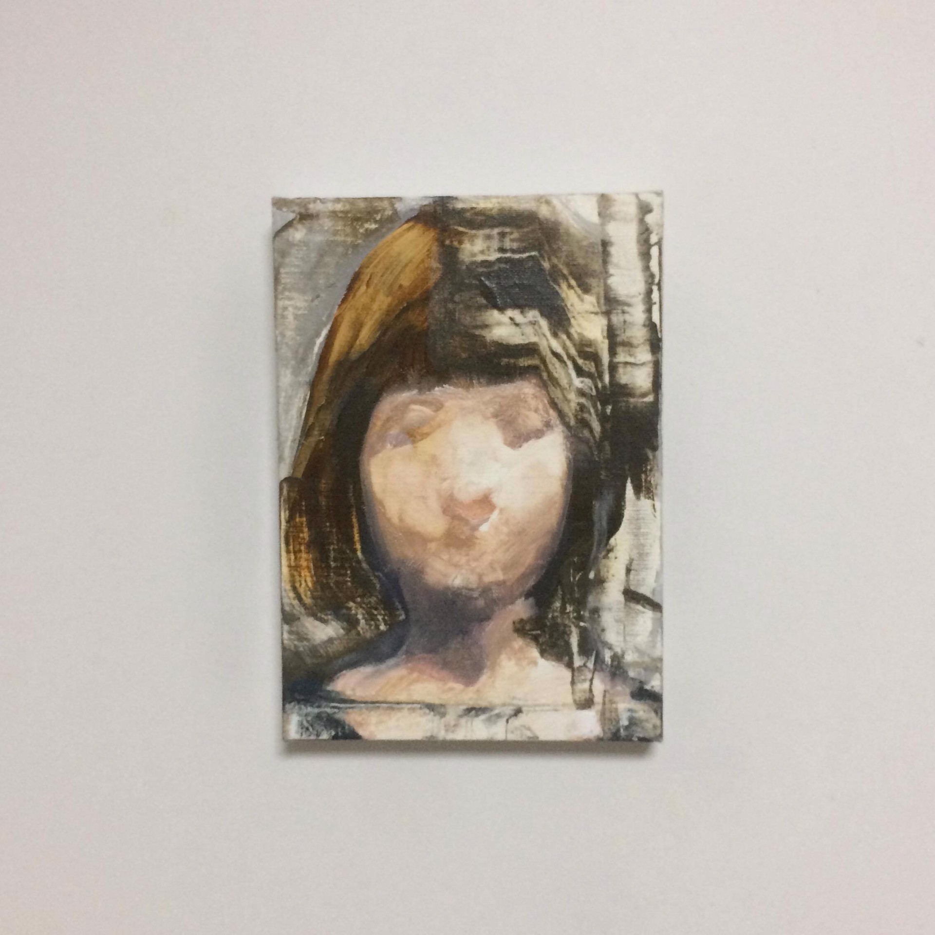 A painting of a woman's face on a white wall.