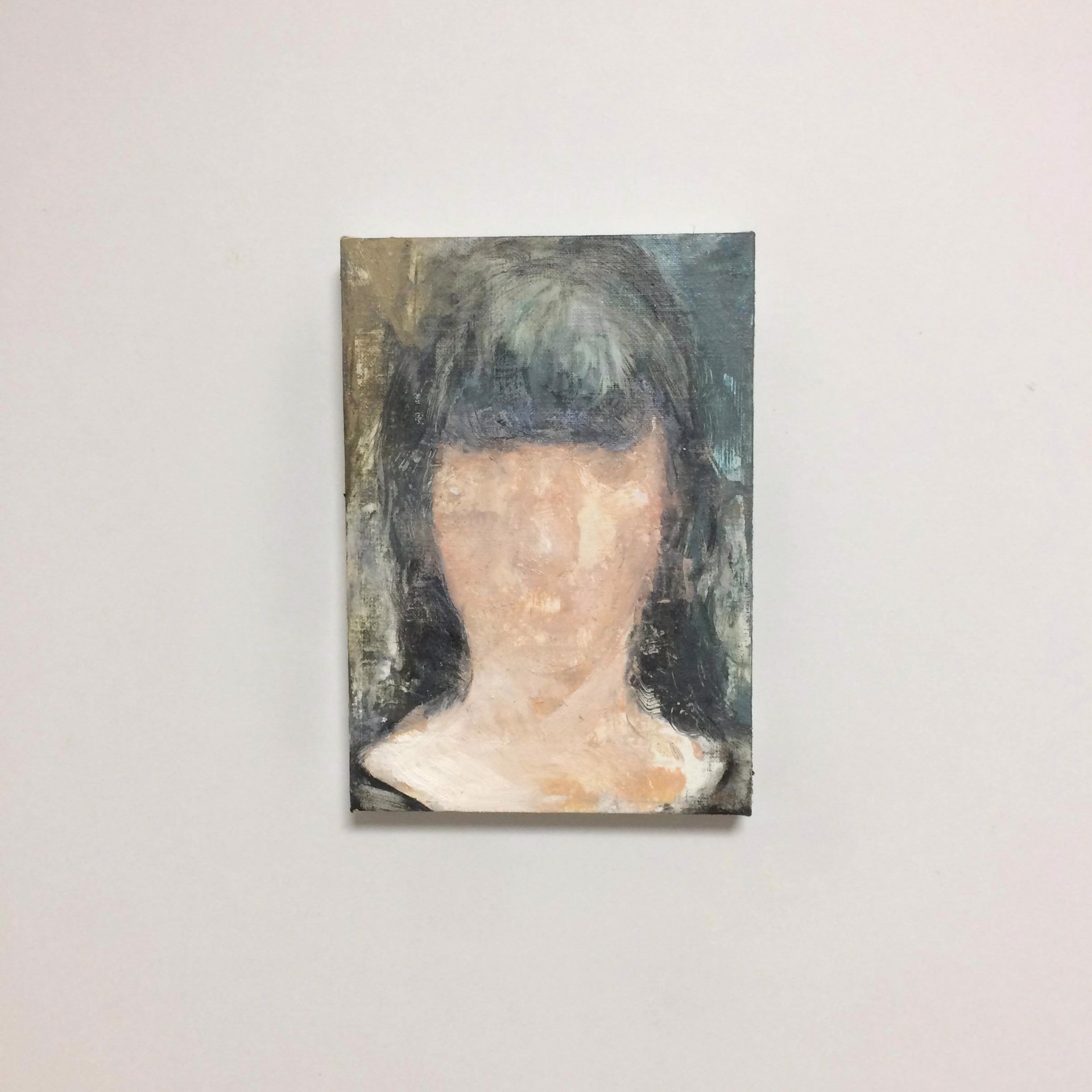 A painting of a woman's face on a white wall.