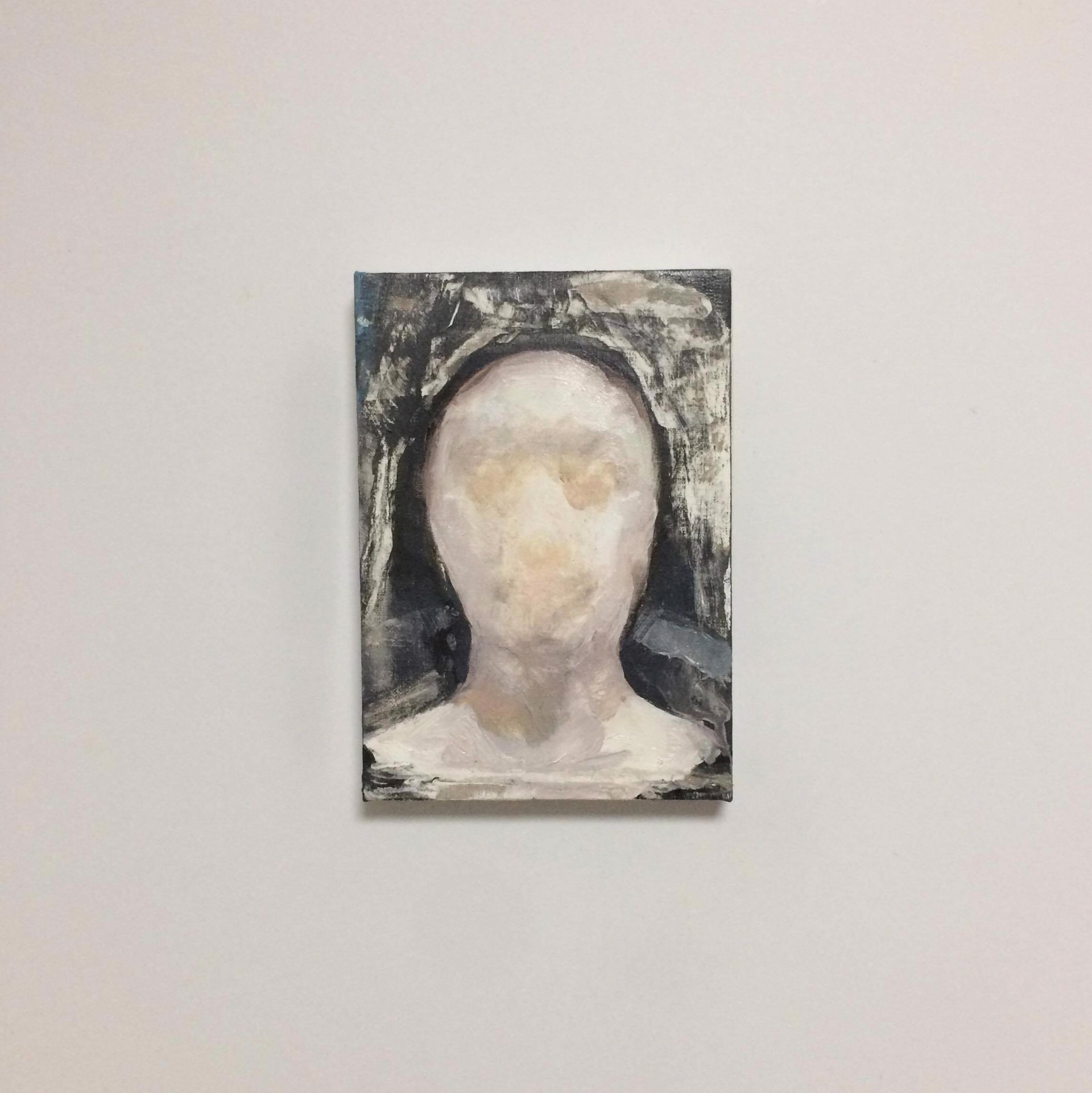 A painting of a woman's head on a white wall.