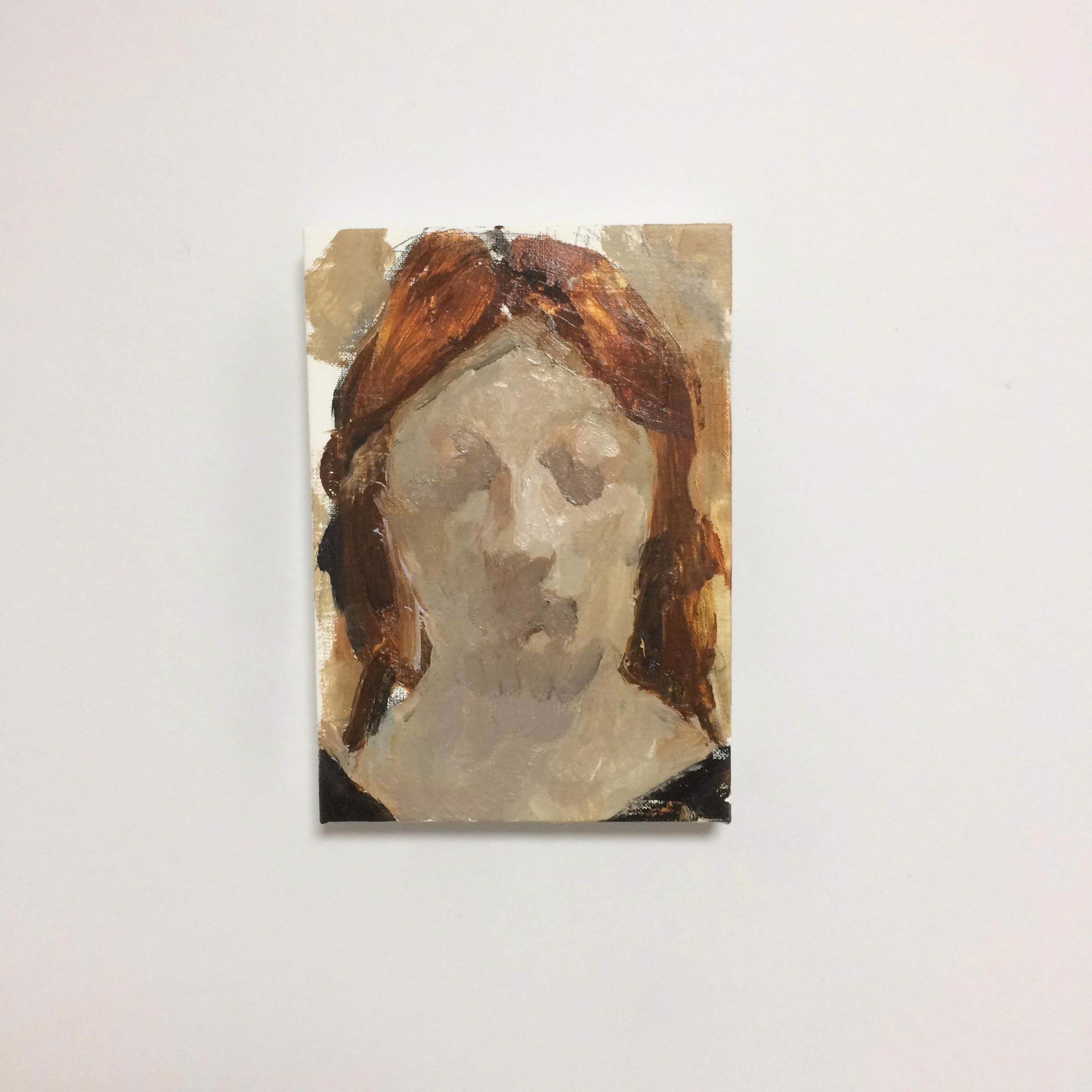 A painting of a woman's face on a white wall.