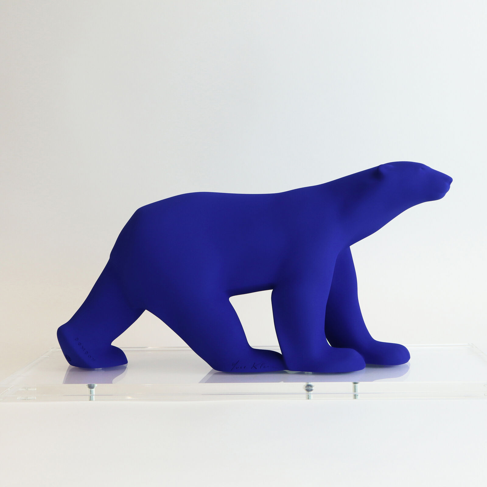 A smooth, matte blue sculpture of a four-legged animal in a walking pose.