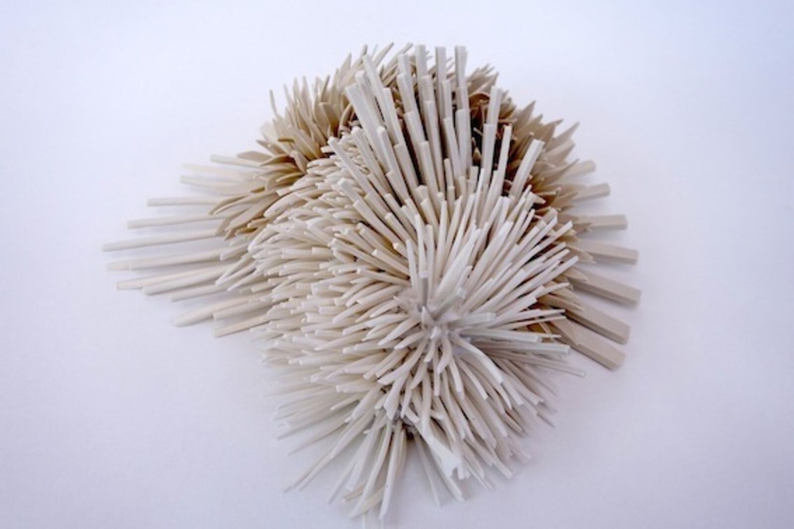 A sculptural heart shape formed from two clusters of spiky, ribbon-like elements.