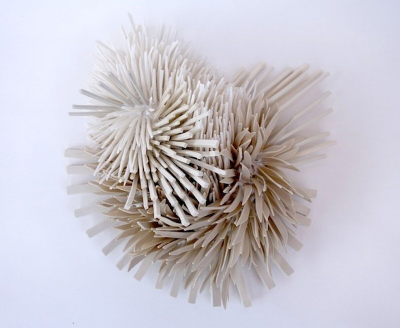 A sculptural heart shape formed from two clusters of spiky, ribbon-like elements.