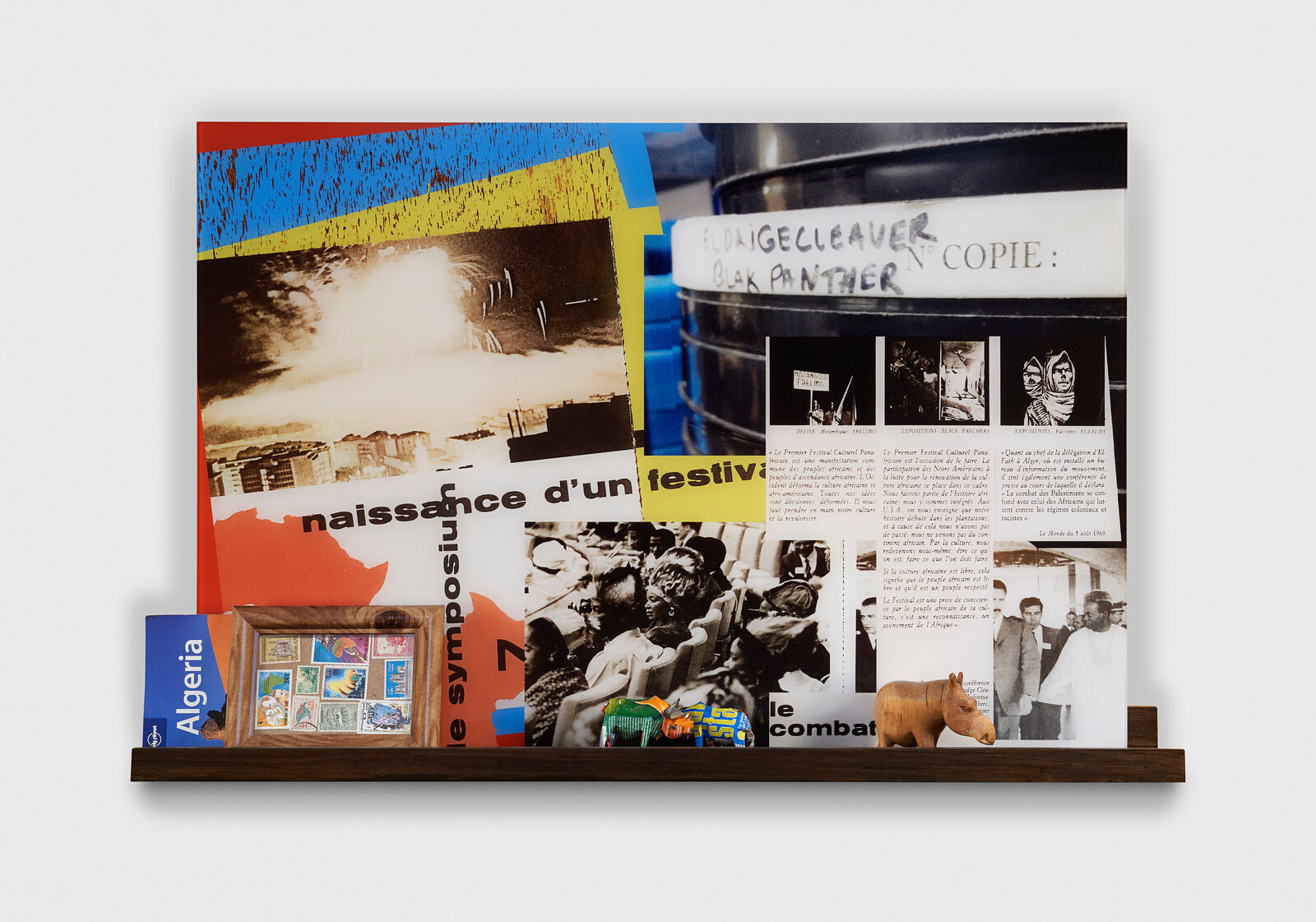 A collage of photos and pictures on a shelf on a wall.