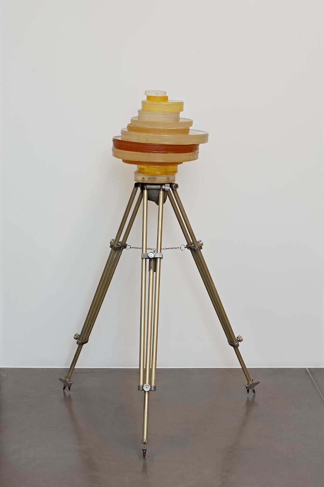 A tripod with a yellow object on top of it.