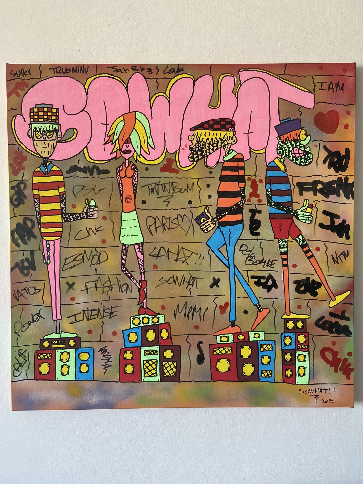A vibrant street art scene featuring four stylized figures standing on colorful blocks against a graffiti-covered wall.
