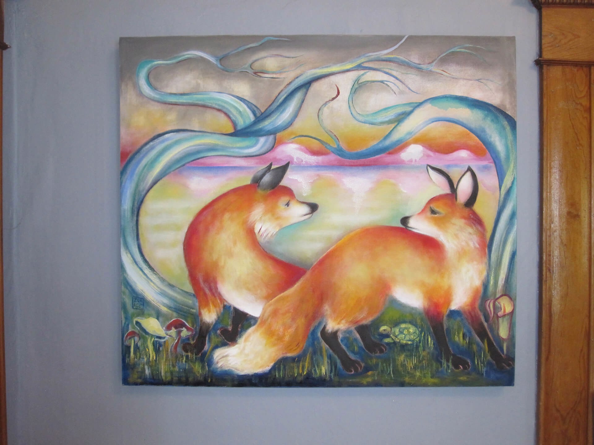A painting of two foxes in a field of grass and trees.