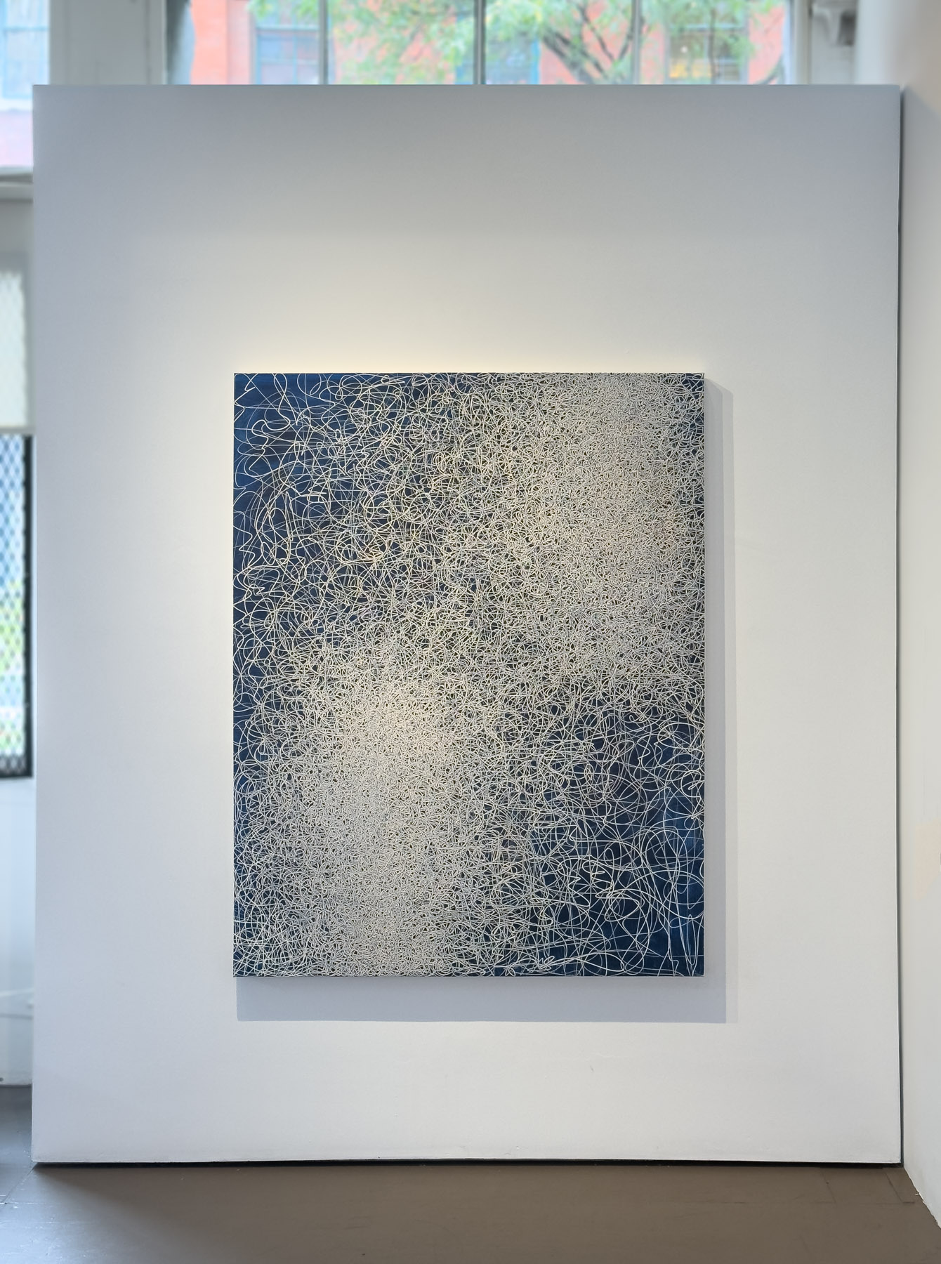 A dense abstract composition of white scribbles on a blue background.