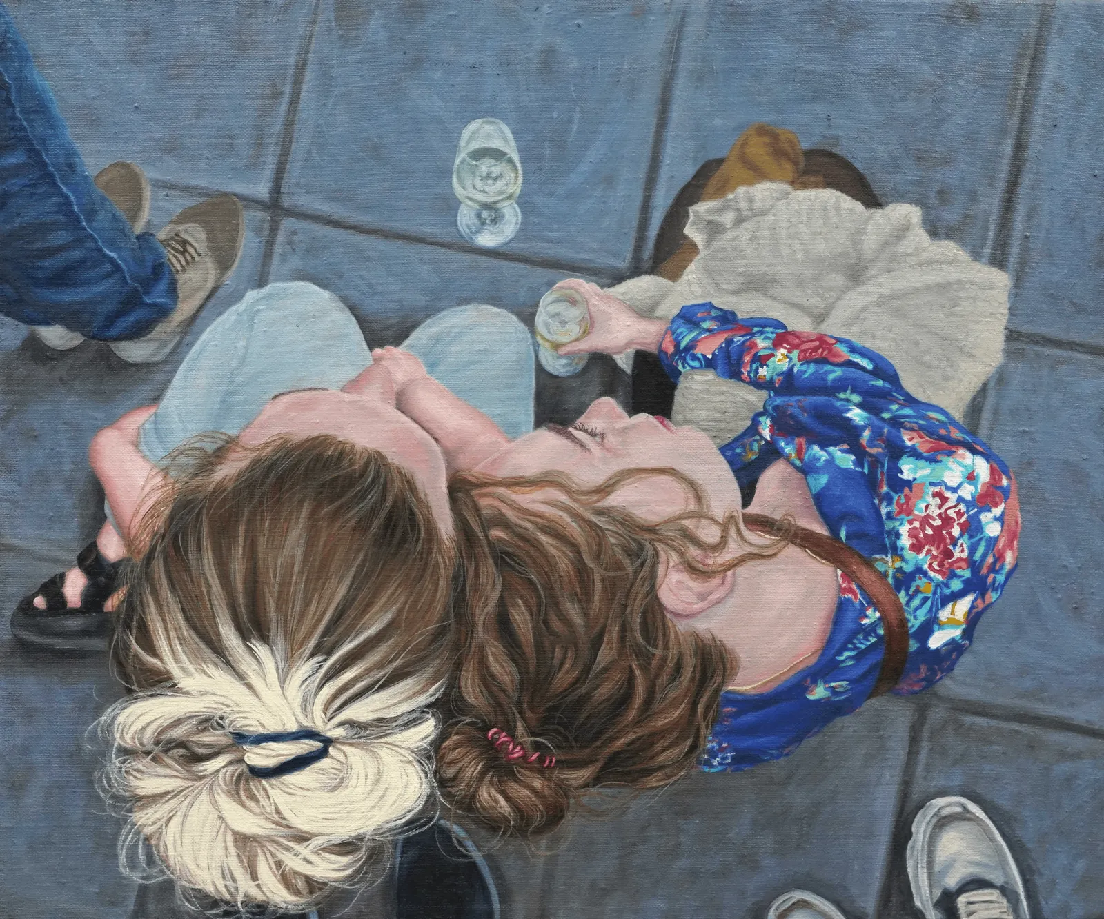 A top-down view of two figures lying on a tiled floor, sharing a quiet moment.