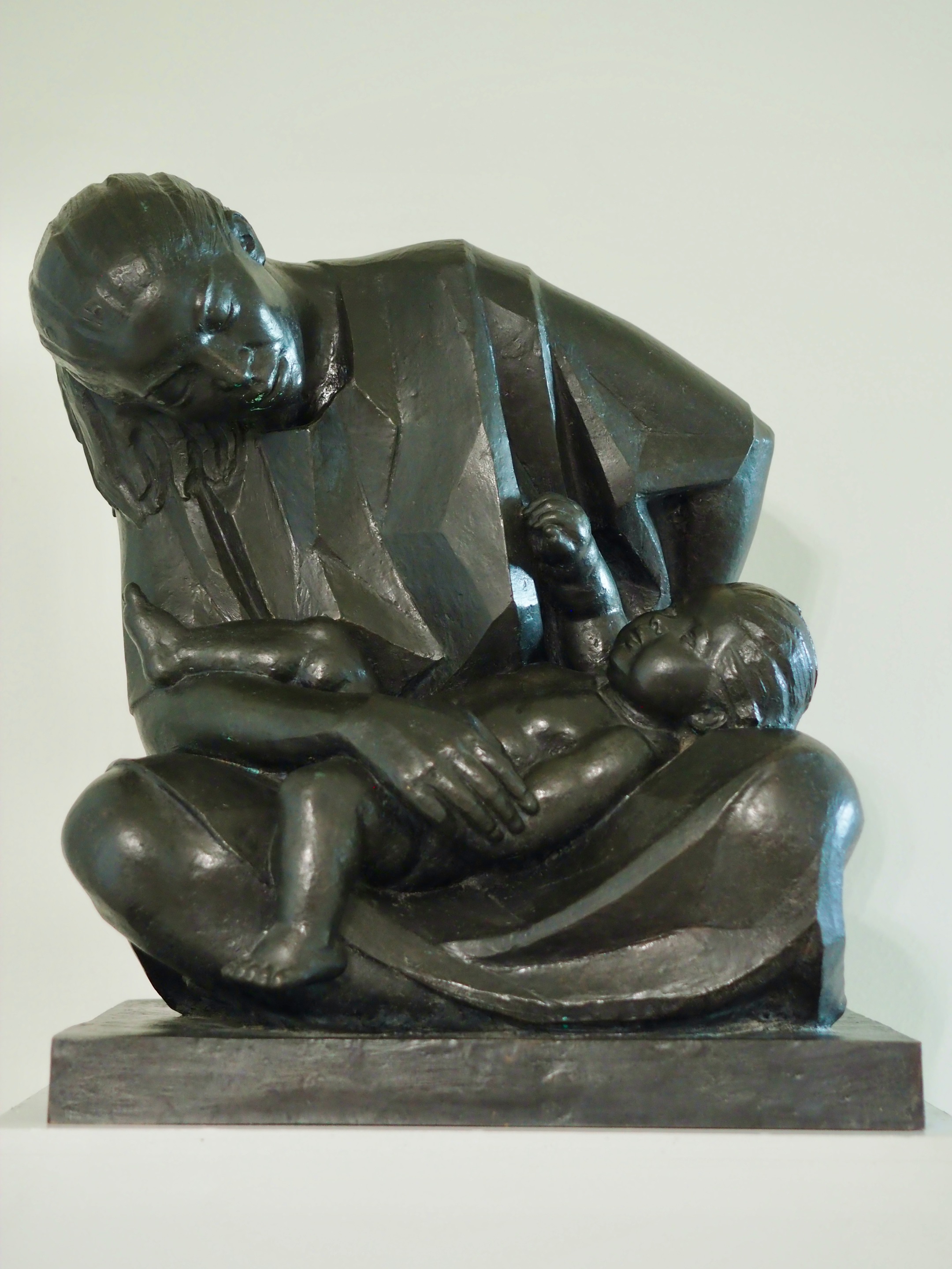 A bronze sculpture of a woman holding a baby.