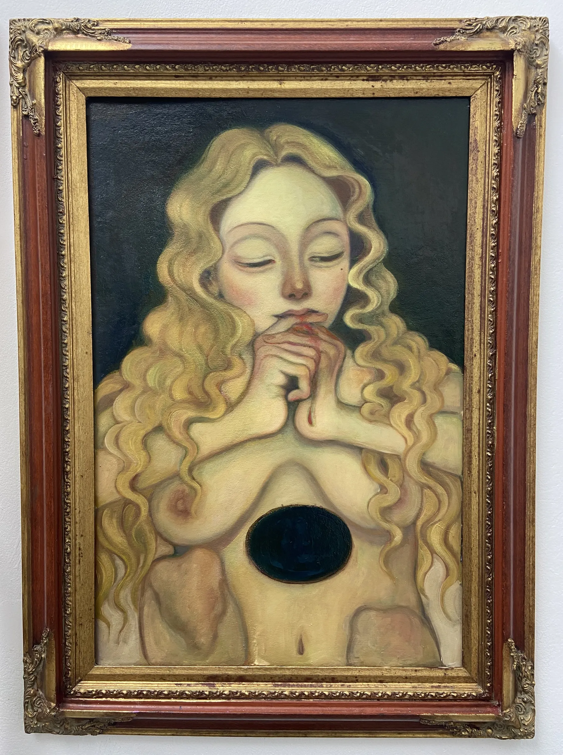 A painting of a woman with long blonde hair in a gold frame.